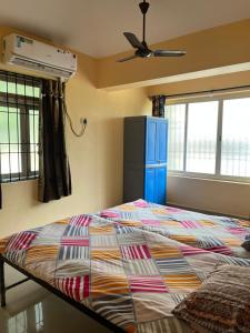 a bedroom with a bed and a blue cabinet and windows at SOMNATH Share House in Queula