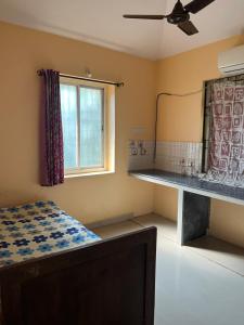 a bedroom with a bed and a mirror and a desk at SOMNATH Share House in Queula