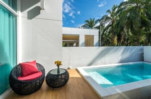 a house with a plunge pool and a red chair at The Garnet Light Pool Villa Aonang-3BR Private Pool Villa in Ao Nang Beach