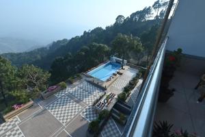 a swimming pool on a balcony with mountains in the background at Hotel Ravine Palace in Lansdowne