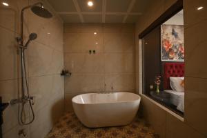 a bathroom with a white tub and a shower at Nhật Long Hotel in Giap Ninh Binh