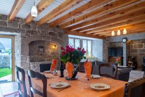 a dining room with a table with flowers on it at Gîte de montchamp in Arzenc-dʼApcher