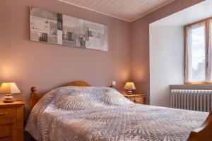a bedroom with a bed and two lamps and a window at Gîte de montchamp in Arzenc-dʼApcher