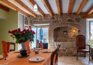 a dining room with a table and a stone fireplace at Gîte de montchamp in Arzenc-dʼApcher +28 photos