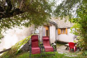 three red chairs sitting in front of a house at La grange - 4/6 personnes in Saint-Pierre-de-Nogaret
