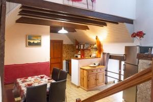a kitchen and dining room with a table and a refrigerator at La grange - 4/6 personnes in Saint-Pierre-de-Nogaret +22 photos