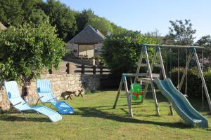 two chairs and a swing set in a yard at La grange - 4/6 personnes in Saint-Pierre-de-Nogaret