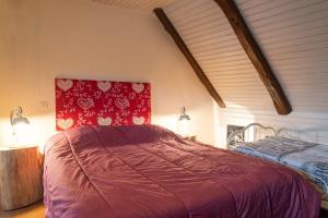 a bedroom with a bed with a red blanket at La grange - 4/6 personnes in Saint-Pierre-de-Nogaret