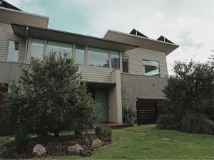 a large house with large windows on a yard at Beach Haven in Point Lonsdale