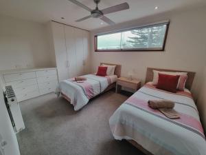 a bedroom with two beds and a window at Beach Haven in Point Lonsdale