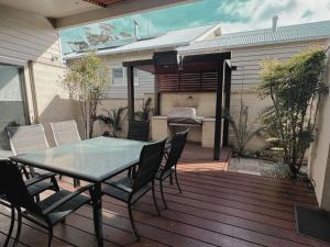 a patio with a table and chairs on a deck at Beach Haven in Point Lonsdale +8 photos