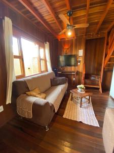 a living room with a couch and a table at Chalé aconchegante Brotas SP + Área Rústica privativa + Ar condicionado in Brotas