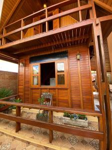 a house with wooden walls and a balcony at Chalé aconchegante Brotas SP + Área Rústica privativa + Ar condicionado in Brotas