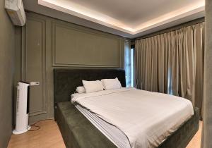 a bedroom with a large bed with white sheets at Ohana Suites Yogyakarta in Yogyakarta +92 photos