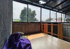 a room with a large window and a wooden floor at Ohana Suites Yogyakarta in Yogyakarta