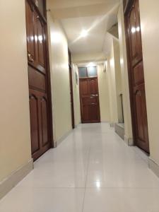 an empty hallway with wooden doors and white floors at HOTEL Omar in Ayacucho