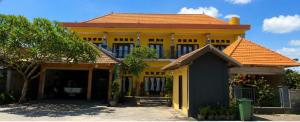 a yellow building with an orange roof at Deva Devi Beach Inn in Sampalan