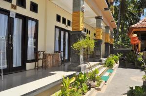 a courtyard of a house with trees and plants at Deva Devi Beach Inn in Sampalan