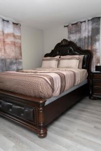 a bedroom with a large bed with a wooden frame at Juliet's Cozy Retreat in Worcester