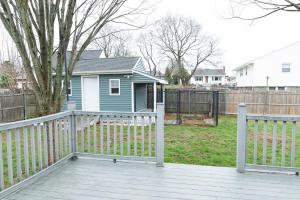 a blue house with a white fence and a yard at Juliet's Cozy Retreat in Worcester