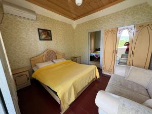 a bedroom with a bed and a couch at Guest House Balda in Martvili
