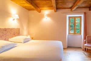 a bedroom with a white bed and a window at Ecogîte cévénola 3 personnes in Molezon