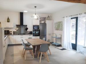 a kitchen with a wooden table and chairs at Maison de l'aire in Fraissinet-de-Fourques