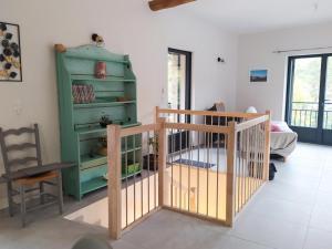 a living room with a green cabinet and a table at Maison de l'aire in Fraissinet-de-Fourques