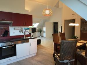 uma cozinha e sala de jantar com mesa e cadeiras em Apartment Maasheuvel em Arcen