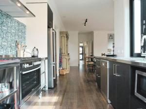 a large kitchen with black cabinets and wooden floors at Chevignon in Queenscliff