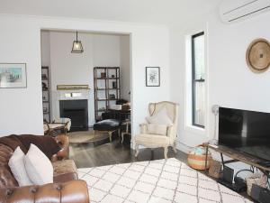 a living room with a couch and a television at Chevignon in Queenscliff