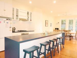 a kitchen with a counter with stools around it at Dinghy s Rest in Queenscliff