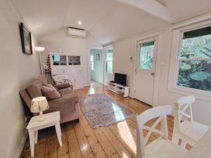 a living room with a couch and a table and chairs at Doongarra in Queenscliff