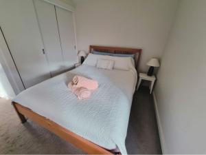 a bedroom with a bed with a pink towel on it at Doongarra in Queenscliff