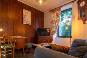 a living room with a couch and a table and a tv at La maison d'anna in Langogne