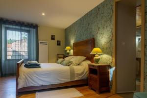 a bedroom with a bed and a table with a lamp at La maison d'anna in Langogne