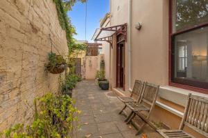 eine Gasse mit zwei Bänken neben einem Gebäude in der Unterkunft Elenora in Queenscliff