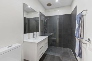 ein weißes Badezimmer mit Waschbecken und Dusche in der Unterkunft Elenora in Queenscliff