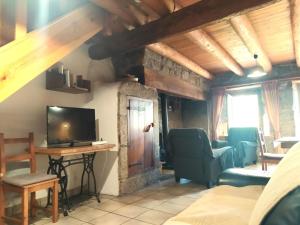 a room with a bed and a television and a table at La drosera in Lajo