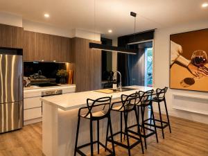 a kitchen with a bar with stools at a counter at Black Sheep alpine getaways in Dinner Plain