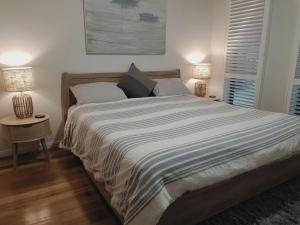 a bedroom with a large bed with two lamps at Flinders Rest in Queenscliff