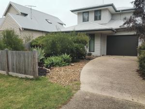 a house with a fence and a driveway at Flinders Rest in Queenscliff