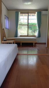 a bedroom with a bed and a large window at 民泊kururu 個室 鍵付き朝パン付きライダー用ガレージ有り in Nishidani