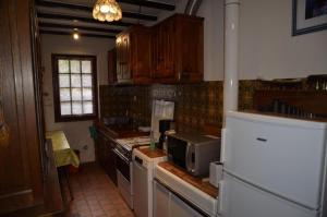 a kitchen with a refrigerator and a microwave at La parrot en margeride in Pierrefiche