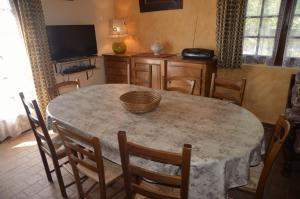 a dining room with a table with chairs and a television at La parrot en margeride in Pierrefiche +16 photos