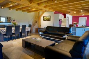 a living room with couches and a table and a kitchen at La maison de clémence 6 personnes in Mialanes
