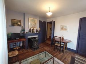 a living room with a fireplace and a table at La maisonnette in Marvejols