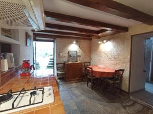 a kitchen and dining room with a table and a stove at La maisonnette in Marvejols