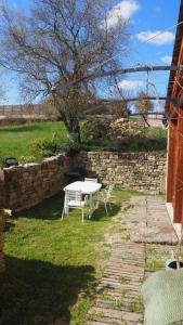 a table and chairs in a yard with a stone wall at La maisonnette in Marvejols +9 photos