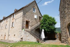 an old stone building with stairs leading up to it at Gîte du boy 8 personnes in Lanuéjols
